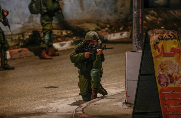 An Israeli soldier seen aiming while other soldiers search shops in the town of Hawara, south of Nablus, in the West Bank. March 25, 2023. (Nasser Ishtayeh / SOPA Images / LightRocket via Getty Images)

Από Jacobin.com