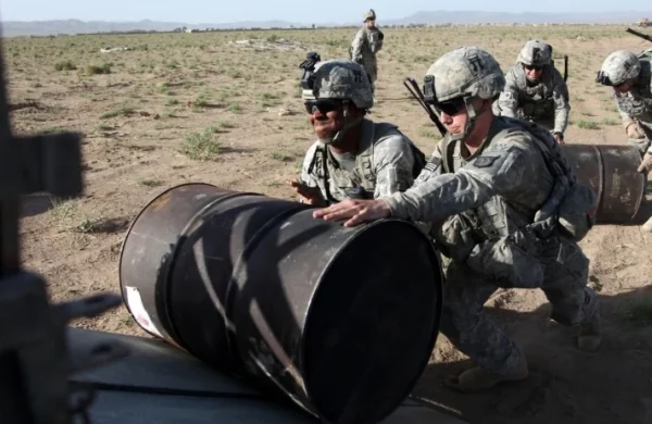 Φωτο αρχείου από Jacobin.com
US soldiers roll barrels of fuel onto a truck during a fuel drop at Forward Operating Base Waza Kwah, Paktika Province, Afghanistan, in July 2010. Jeffrey Alexander / US Army