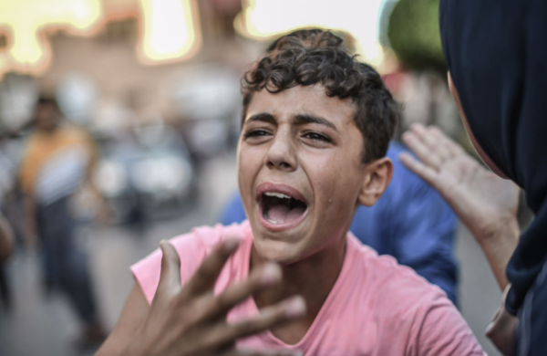 Ένα παιδί θρηνεί τον θάνατο συγγενή του σε ισραηλινή επίθεση στη Γάζα, Παρασκευή 13 Οκτωβρίου. (Abed Zagout / Anadolu via Getty Images)